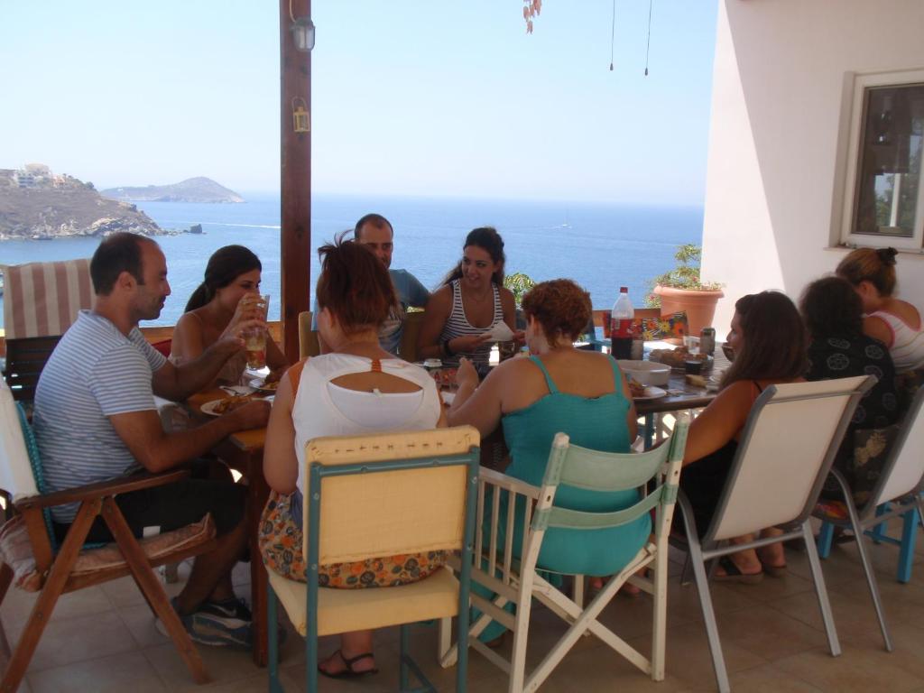 un grupo de personas sentadas en una mesa en un restaurante en Traditional apartment en Kalymnos