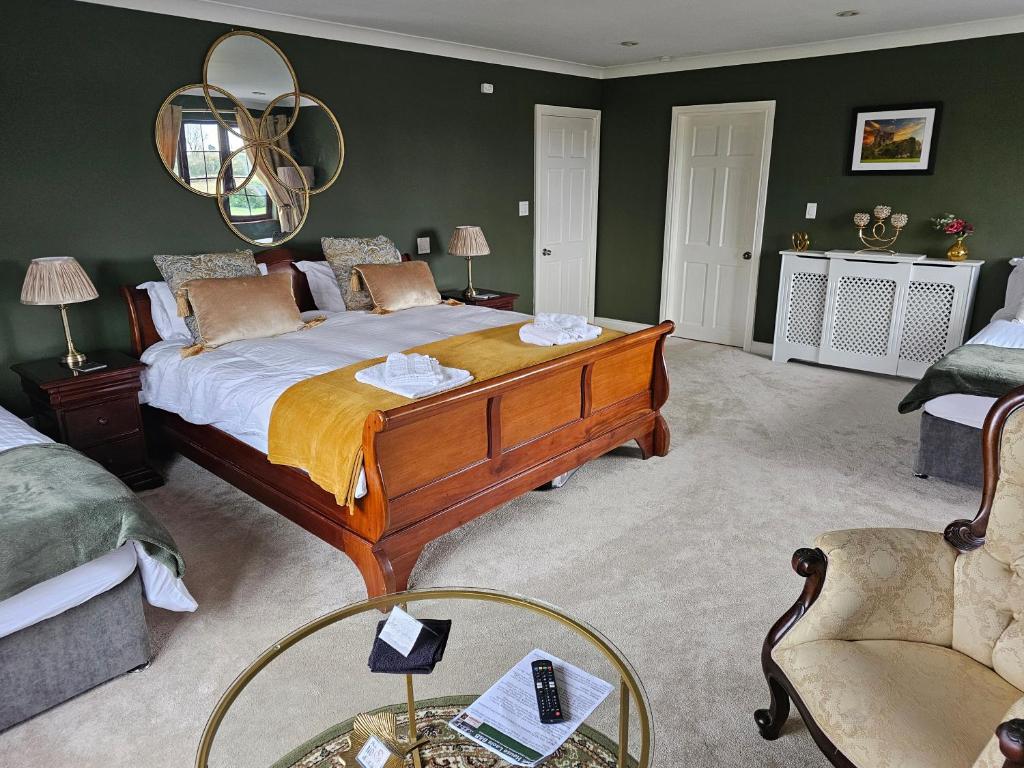 Oak House Laois B&B في بورتارلينغتون: غرفة نوم بسرير كبير وكرسي