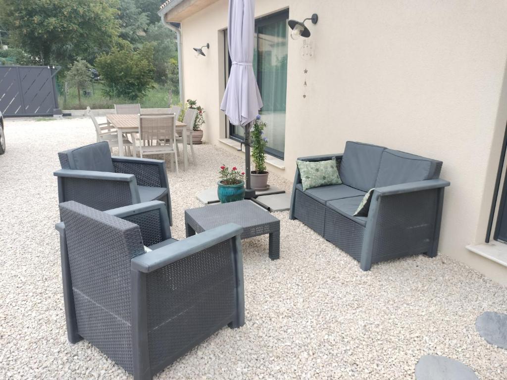 een patio met stoelen, een bank en een tafel bij villa avec jacuzzi in Malaucène