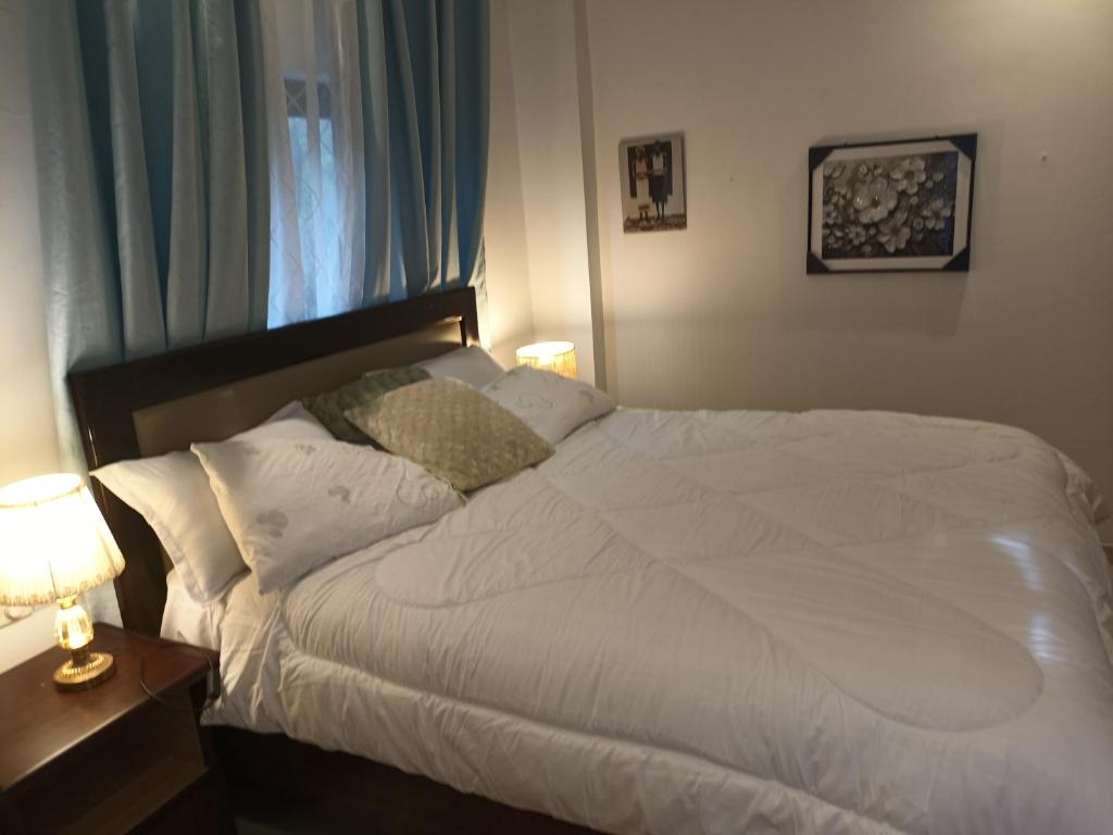 um quarto com uma cama branca e uma janela em ADB Properties em Ogbojo
