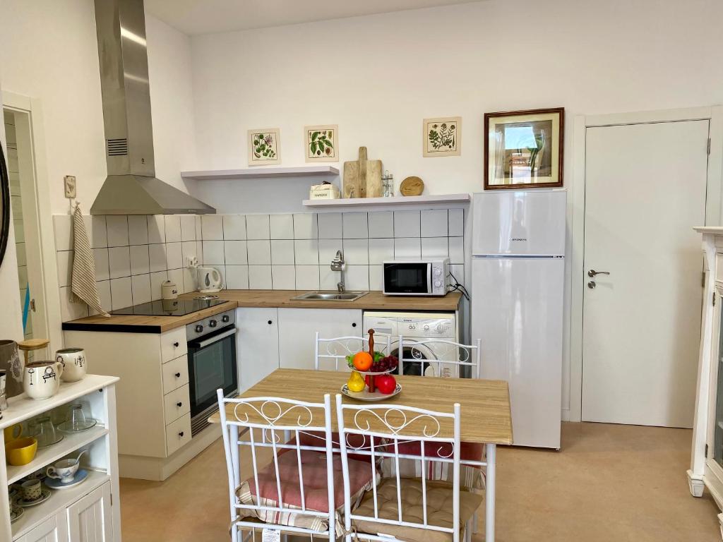 eine Küche mit einem Tisch und einem weißen Kühlschrank in der Unterkunft Apartamento en Almenara a 4 KM de la playa in Almenara