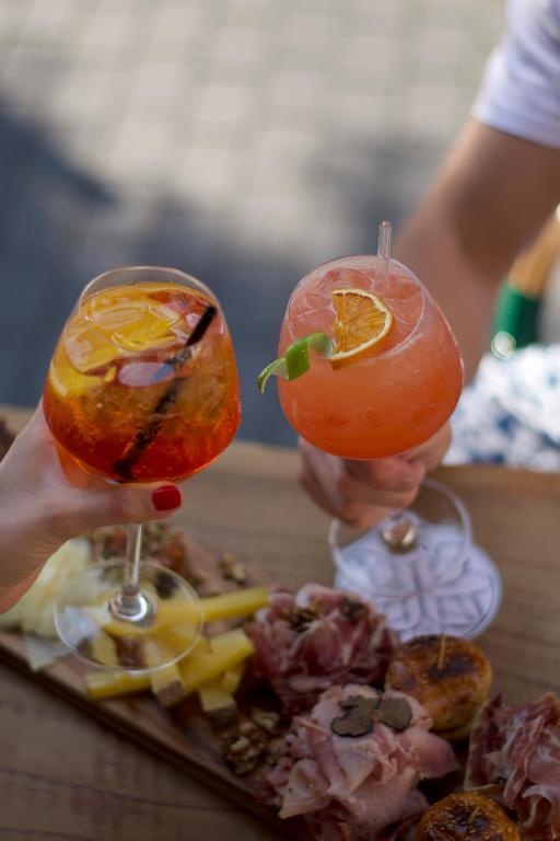 a person holding two glasses of food on a table at LOLA Boutique Hôtel - Bordeaux Centre in Bordeaux