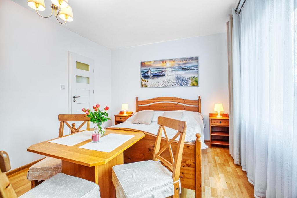 a bedroom with a bed and a table and chairs at Willa Muszelka Przy Morzu in Jastarnia