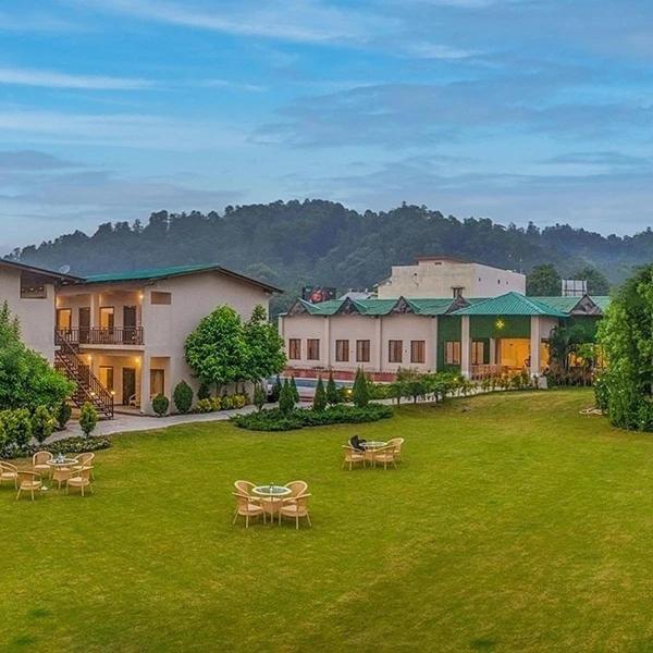 a yard with tables and chairs and a house at VOW HOTELS AND RESORTS in Belparāo
