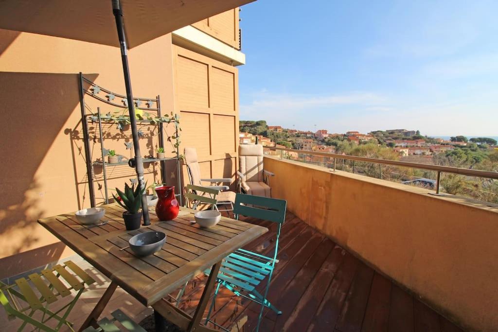une table et des chaises en bois sur un balcon dans l'établissement Joli T2 à 10min à pied du village, parking, vue dégagée, résidence au calme, à Collioure