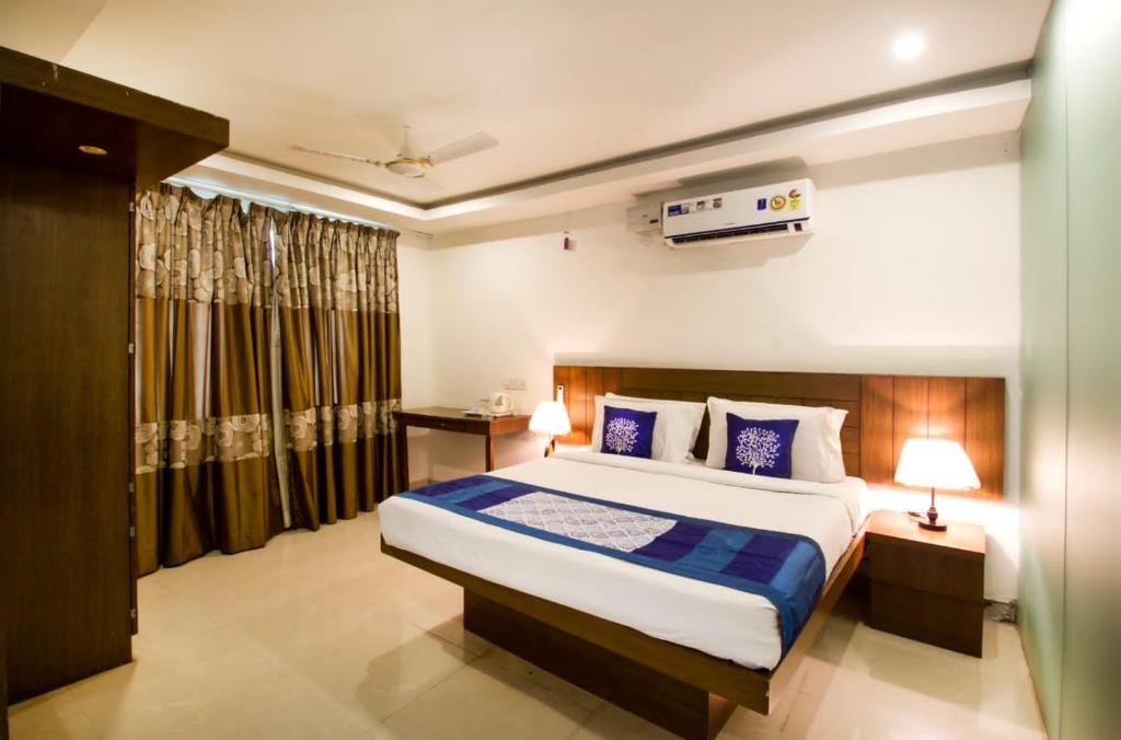a bedroom with a large bed in a room at Rainbow International Hotel Airport Zone Shamshabad in Shamshabad