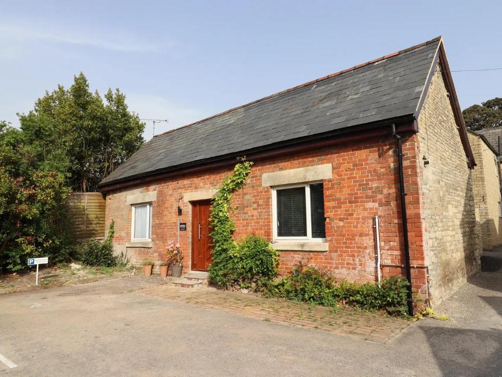 a brick building with a window and a door at Mayfield Cottage in Malmesbury