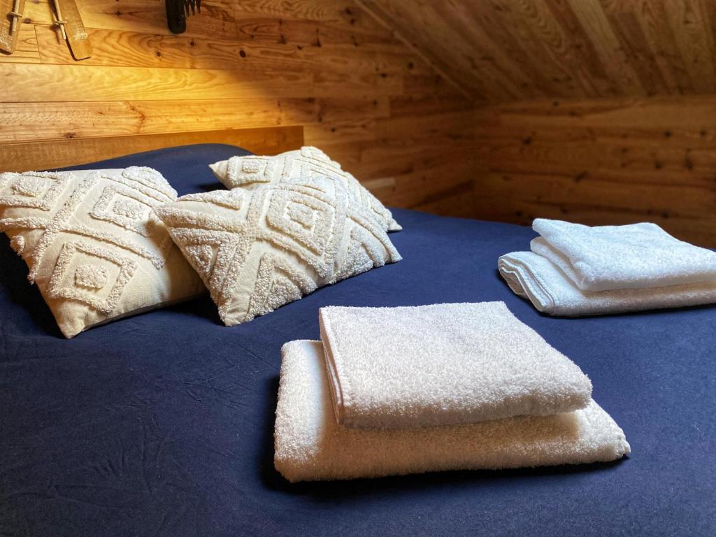 a bed with two towels and two pillows on it at Le Chalet in Verdun-sur-Meuse