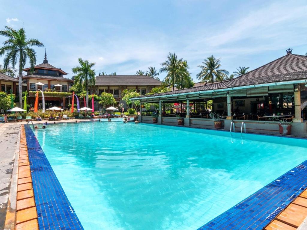 a large swimming pool at a resort at Suite Hotel Apartment Legian by RCP in Seminyak