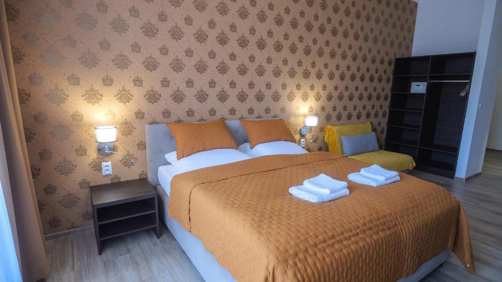 a bedroom with a bed with two towels on it at Premium City Centre Bedrooms in Prešov