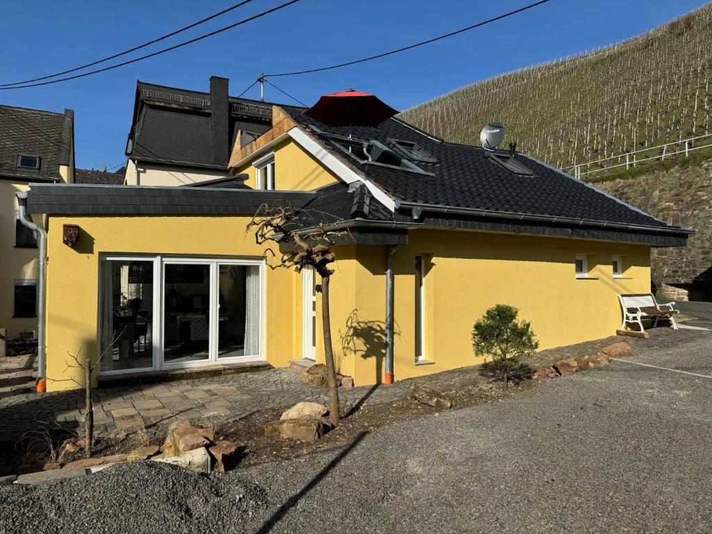 ein gelbes Haus mit schwarzem Dach in der Unterkunft Ferienhaus Merl in Zell an der Mosel