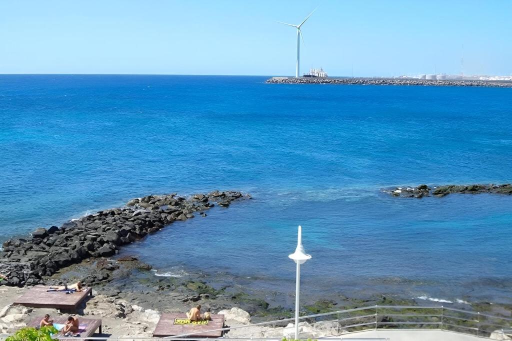 Una vista del océano con una turbina eólica en Sun and Sea House 3 Rooms & Wifi, en Arinaga