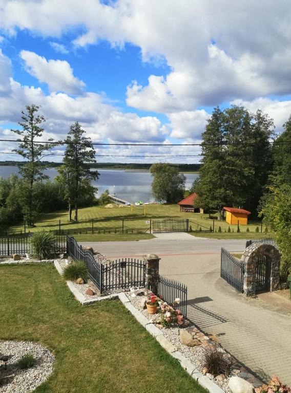 a park with a fence and a view of a lake at Apartament u Rybaka in Sędki