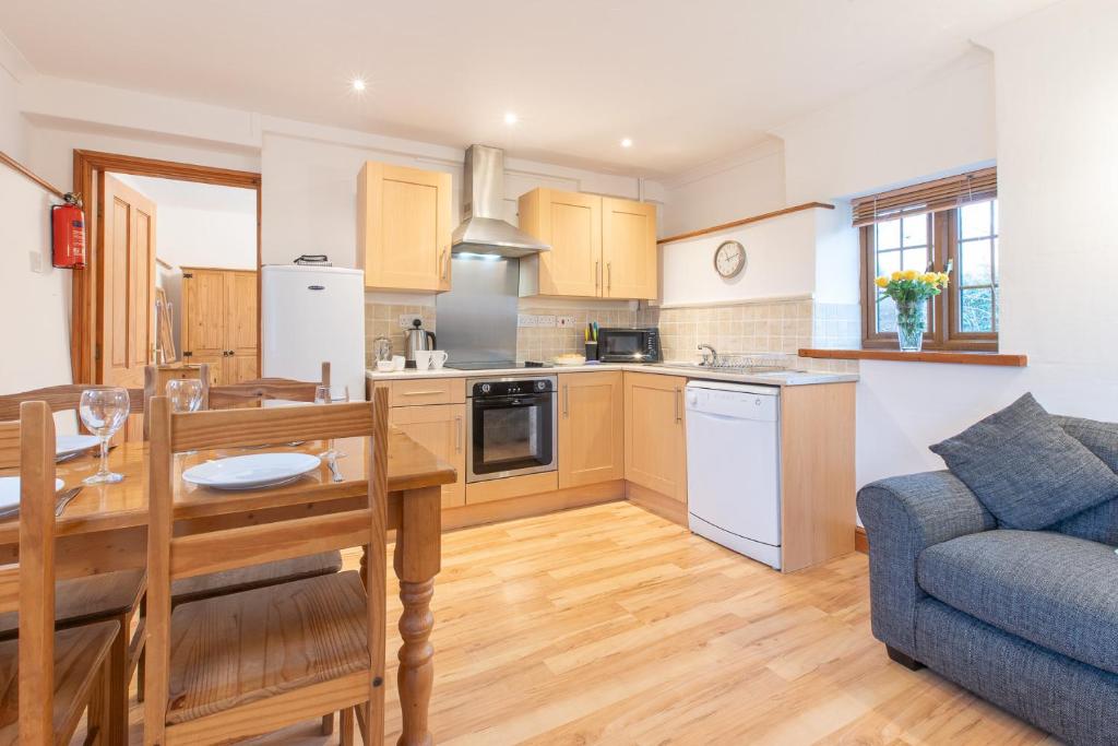 cocina y sala de estar con mesa y sofá en Elidir Cottage, en Llanfairpwllgwyngyll