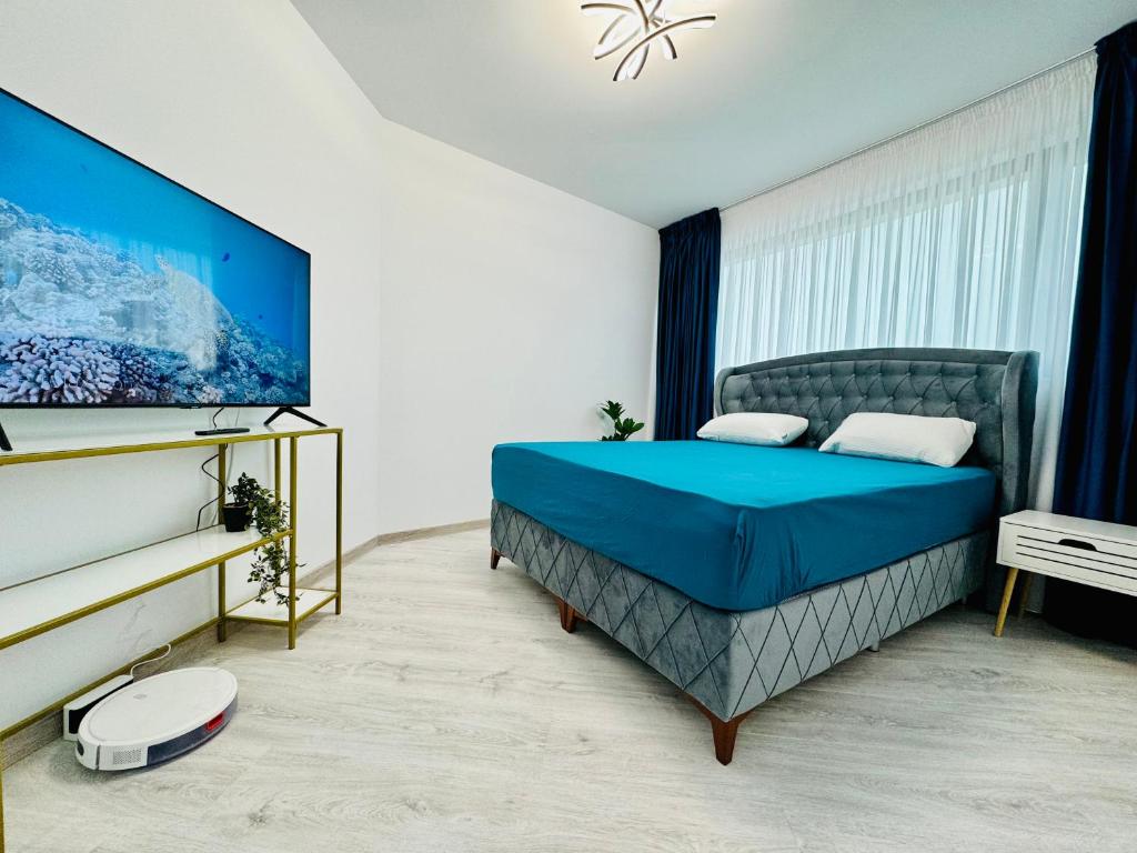 um quarto com uma cama azul e uma janela em Altheda Living Avanera 9B-144 em Suceava