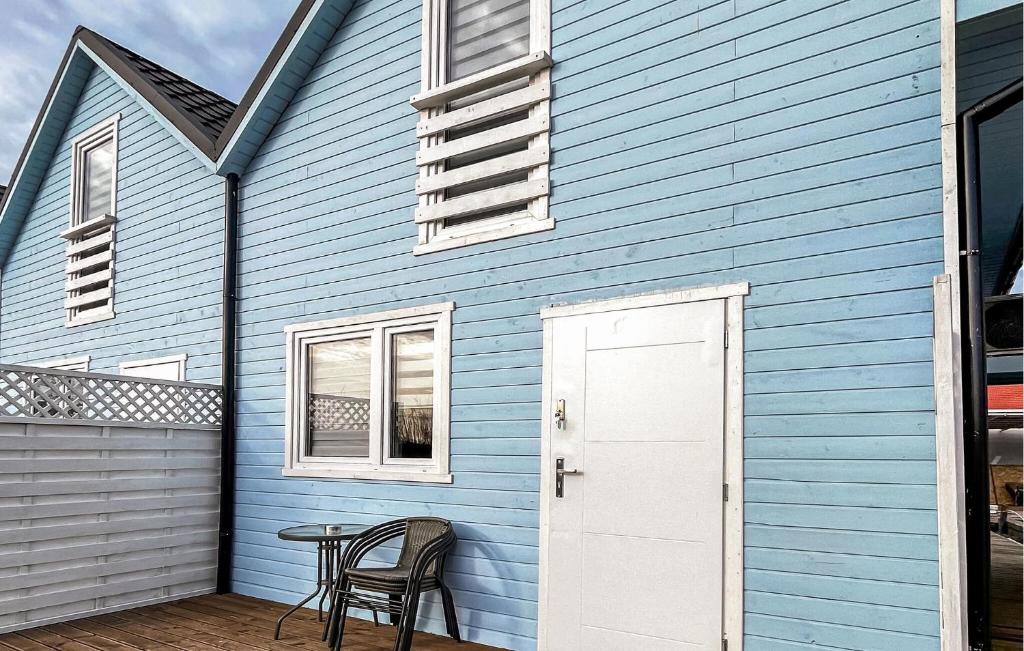 ein blaues Haus mit einem Tisch und Stühlen auf einer Terrasse in der Unterkunft Cozy Home In Rewal With Outdoor Swimming Pool in Rewal
