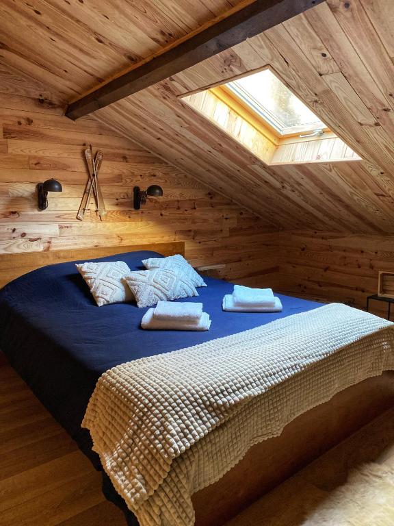 une chambre avec un grand lit dans un grenier dans l'établissement Le Chalet - Centre-Ville - Ambiance chaleureuse - Géré par Presta-Zen'Services, à Verdun-sur-Meuse