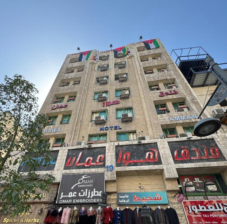 un edificio alto con letreros a un lado. en Downtown Hawaa Amman Hotel en Amán