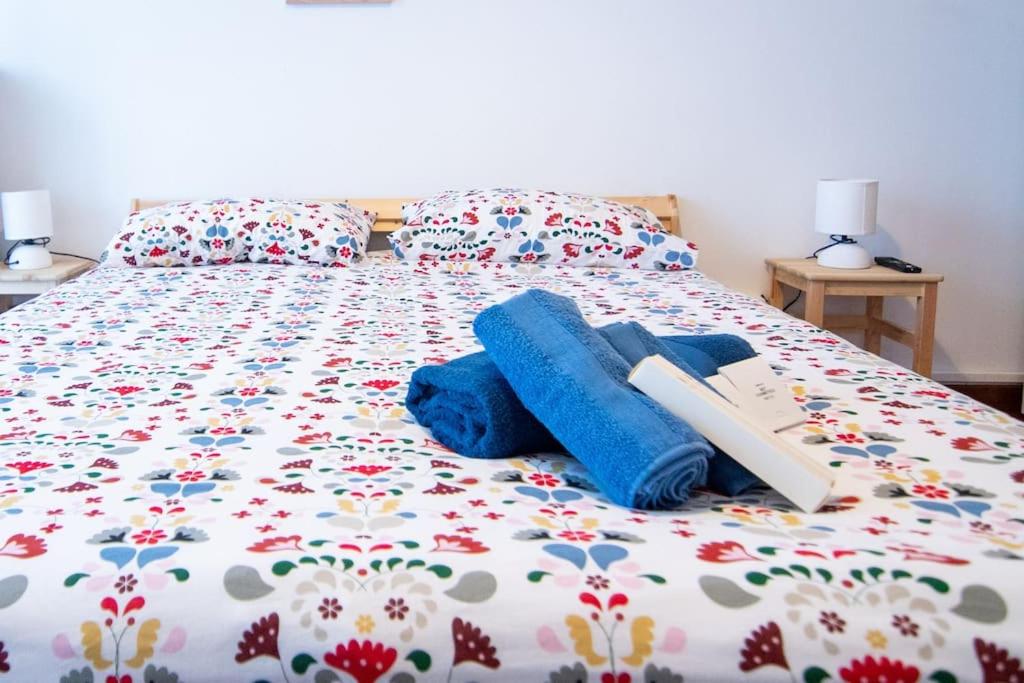 a bed with blue blankets and pillows on it at [15min to Downtown] Cozy Escape in Milan in Milan