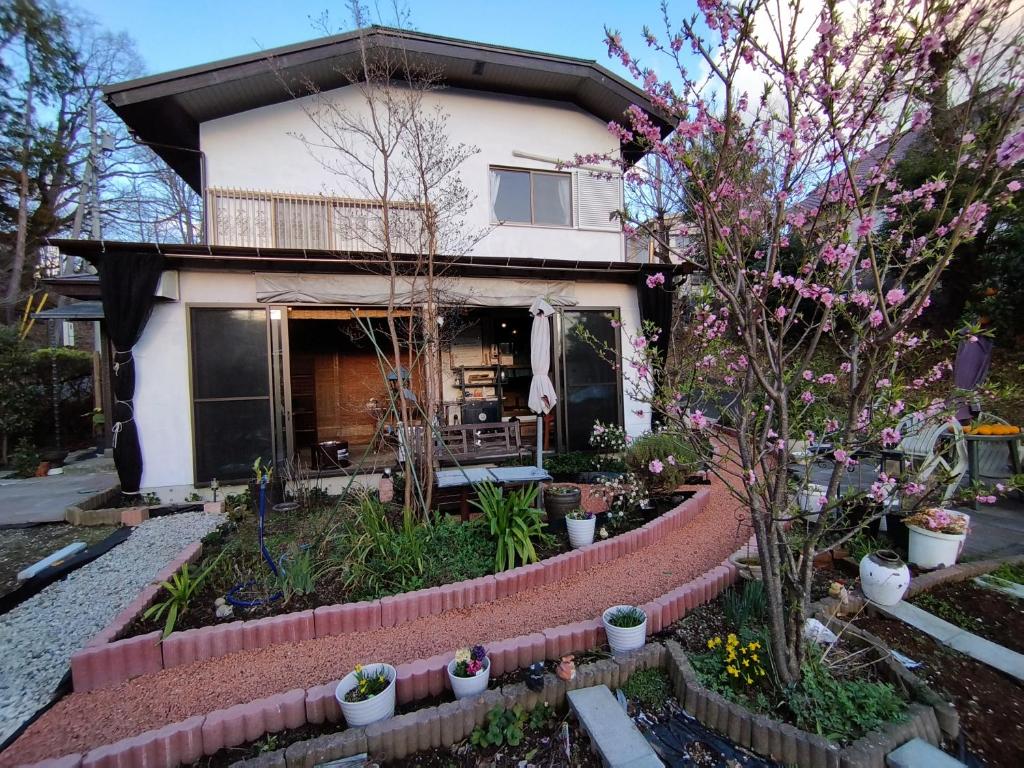 a house with a garden in front of it at Pension Izukogen in Ito