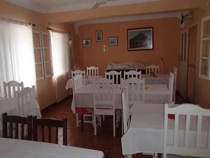 a dining room with white tables and white chairs at Pensão Restaurante Christine & Irmãos in Igreja