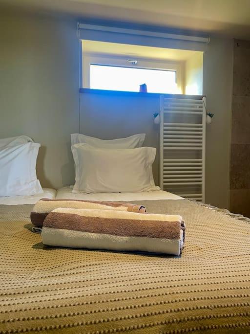 a bed with two towels on top of it at Domaine Clos Carron Studio 2 personnes L&#39;Olivier in Saint-Amour-Bellevue