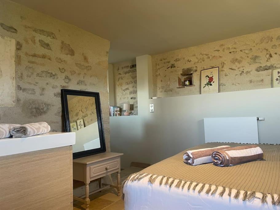 a bedroom with a bed and a dresser with a mirror at Domaine Clos Carron Studio 2 personnes L&#39;Olivier in Saint-Amour-Bellevue