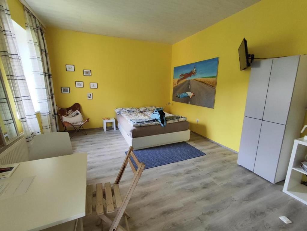 uma sala de estar com paredes amarelas e um sofá em TheGarden Bed&Bike em Gmunden
