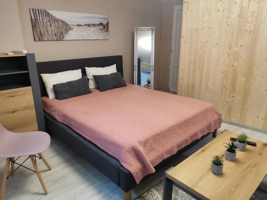 um quarto com uma cama com uma colcha rosa em Апартаменты в центре Ужгорода СКАЛА em Uzhhorod