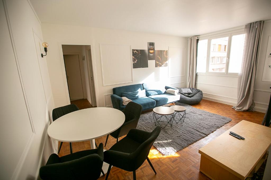 巴黎的住宿－Luxury Appartement Batignole，客厅配有蓝色的沙发和桌子