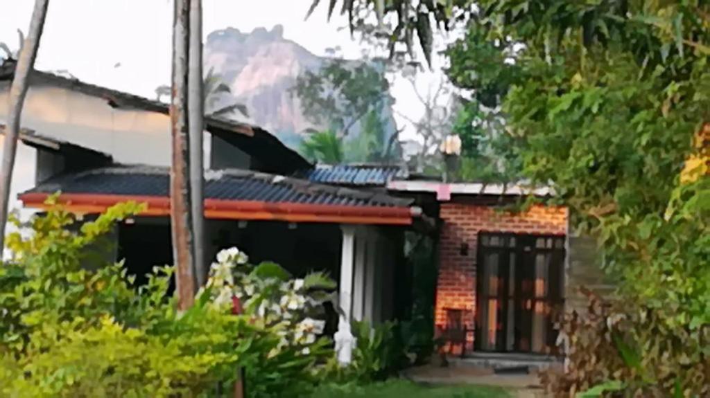 a brick house with a window in a yard at Tezara Home Stay in Sigiriya