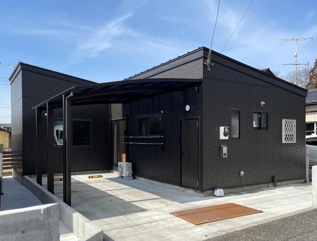 a black building with a black covering on it at 一棟貸しnuevoL7～暮らすように泊まる北群馬の冒険はここから in Numata