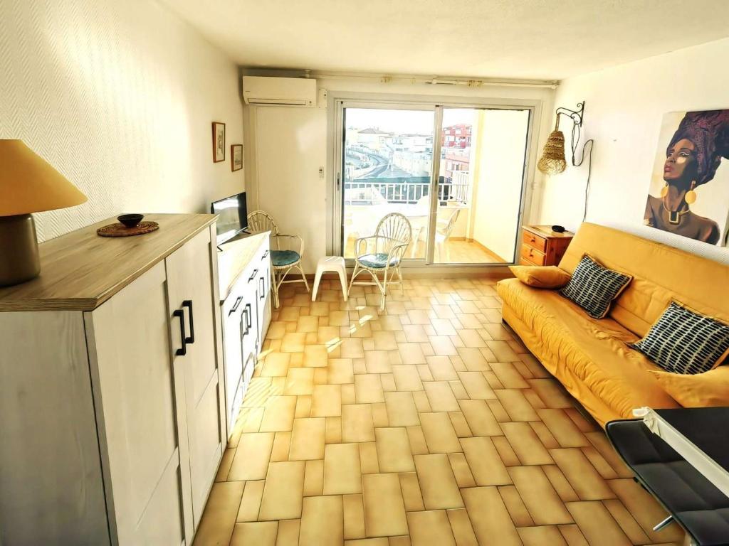 un salon avec un canapé jaune et une cuisine dans l'établissement Studio climatisé avec piscine et parking à 20m de la mer - FR-1-607-75, au Cap d'Agde