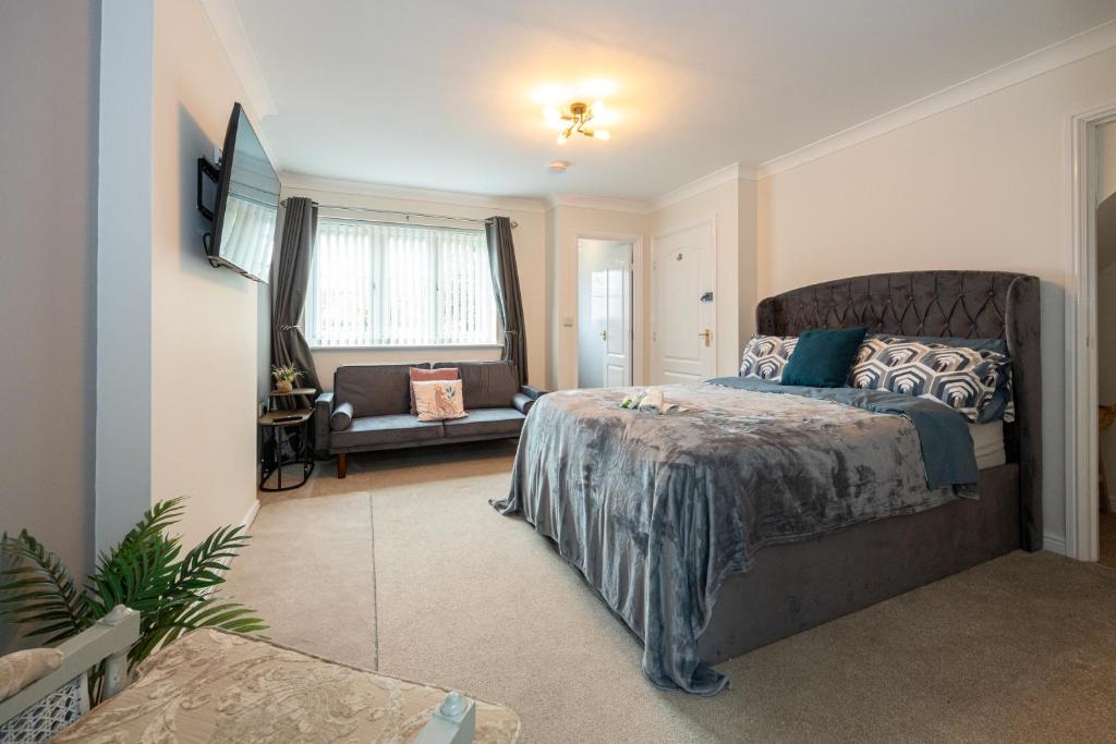 a bedroom with a large bed and a living room at Airstays Apartment in Wythenshawe