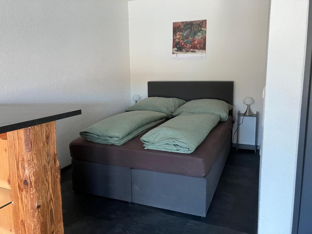 een bed met groene kussens in een kamer bij Jenszu Ferienwohnung in Balingen
