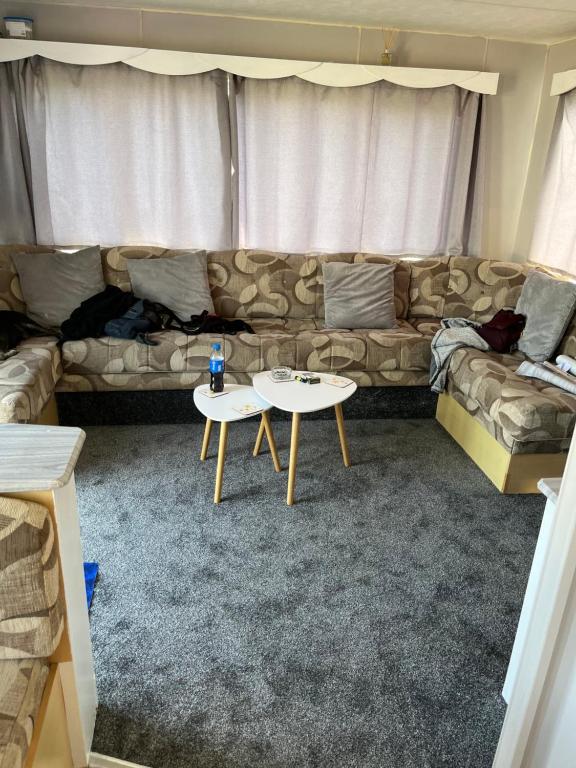 - un salon avec un canapé et une table dans l'établissement Caravan, à Mablethorpe