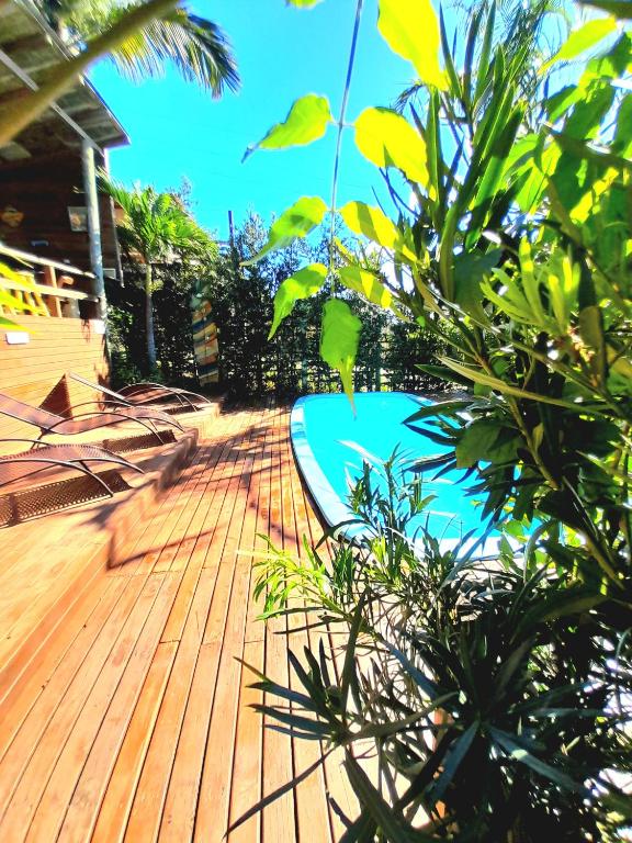 a wooden deck with a swimming pool on a house at Pousada Baia Rosa in Praia do Rosa