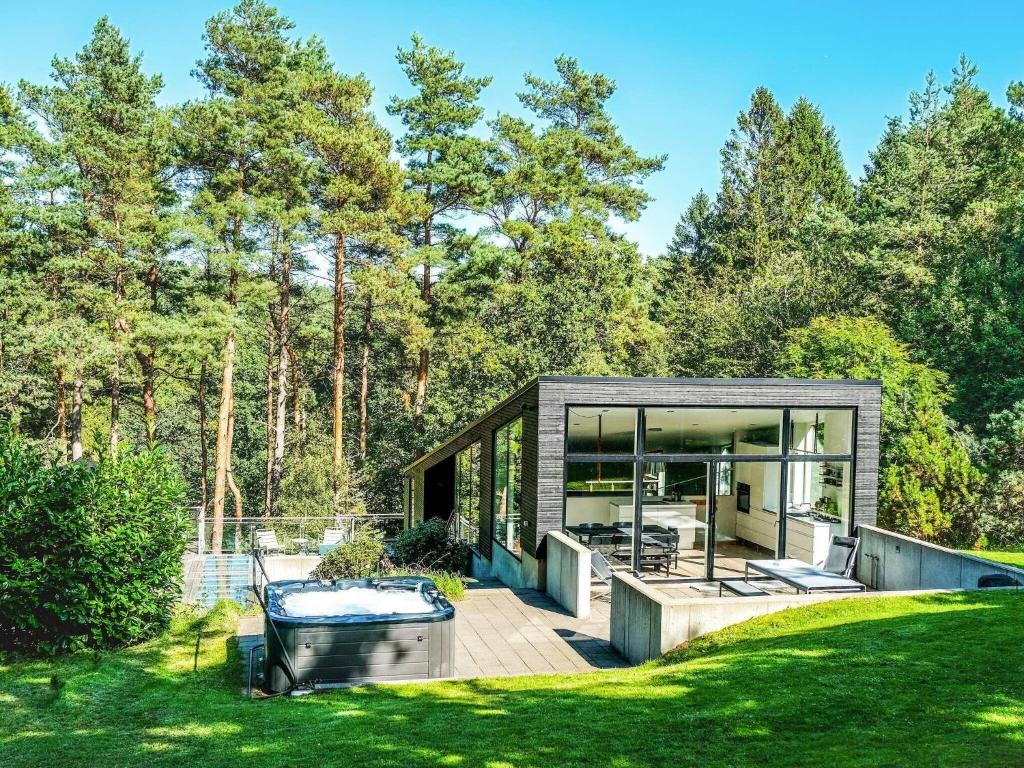 una pequeña casa con terraza y cristal en 8 person holiday home in Ebeltoft en Ebeltoft