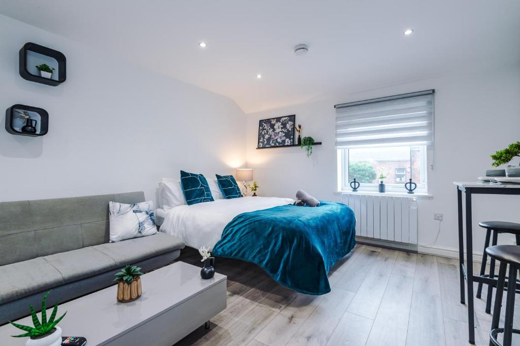 a bedroom with a bed and a couch at Modern Studio Apartment in Wigan in Hindley