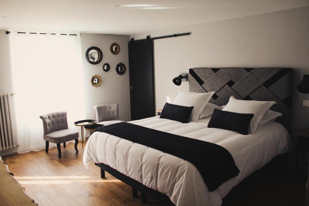 a bedroom with a large bed and a window at Au bois Noël - LE CHARME in Lescherolles