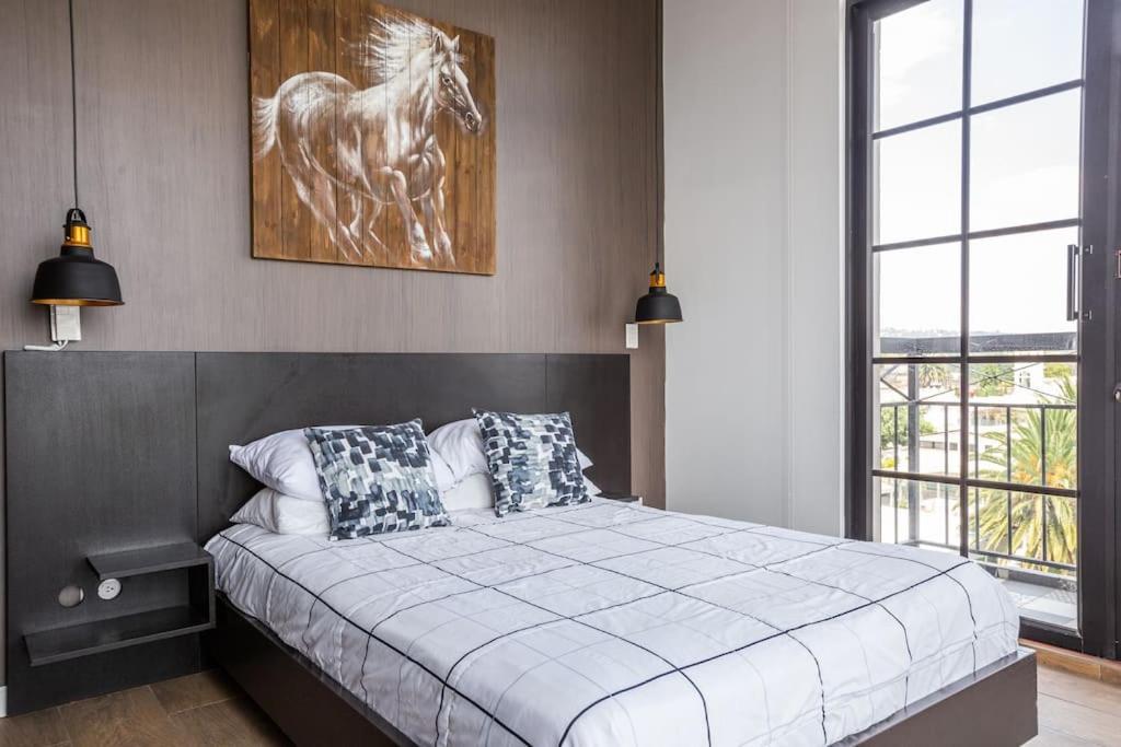 - une chambre avec un lit avec une photo d'un cheval dans l'établissement Mumbai Penthouse Studio, à Quito
