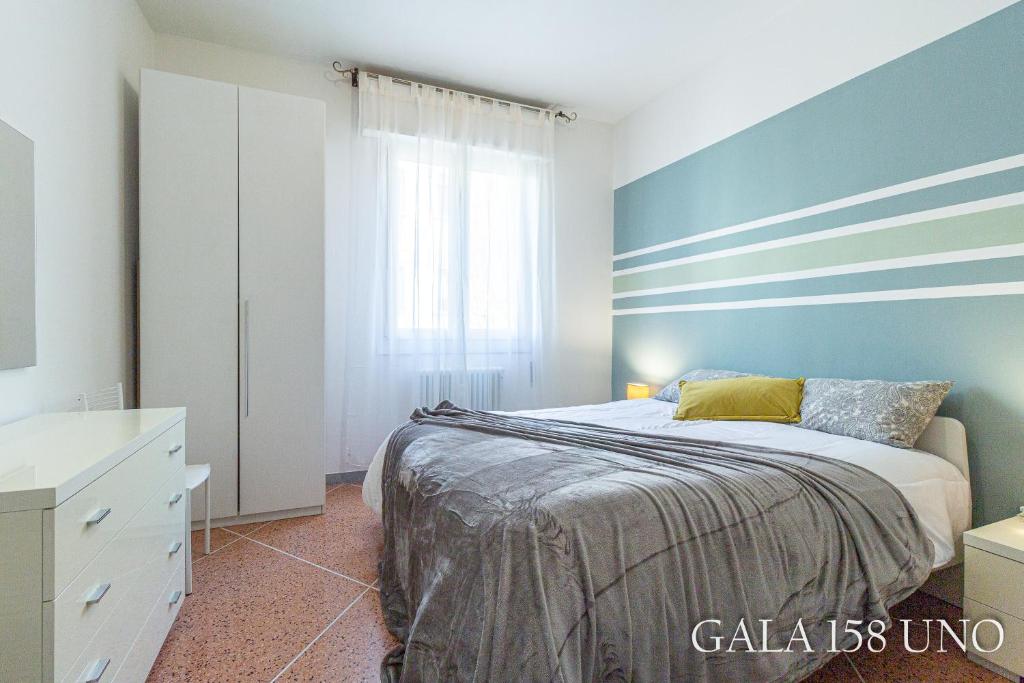 una camera da letto con un letto e una parete blu di Gala158UNO Fair With Parking a Bologna