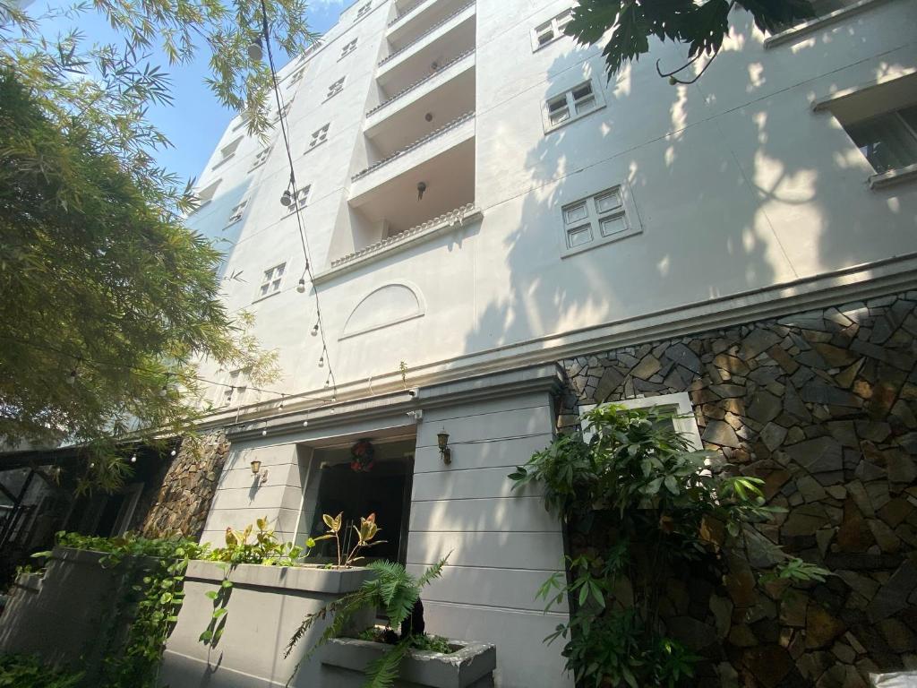 a white building with a door in front of it at Amura Hotel Thủ Đức in Ho Chi Minh City