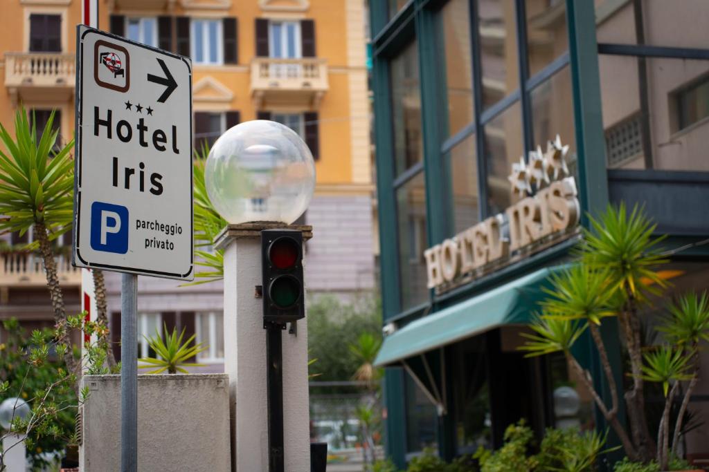 a street sign and a traffic light in front of a hotel at Hotel Iris in Genoa