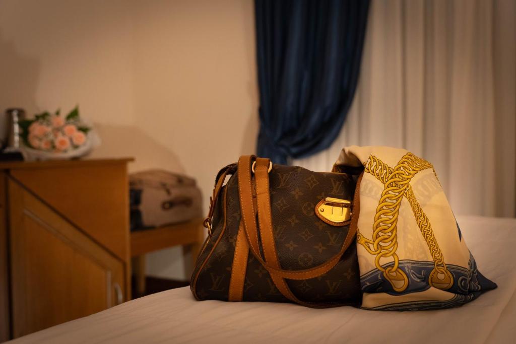 a purse sitting on top of a bed at Hotel Iris in Genoa