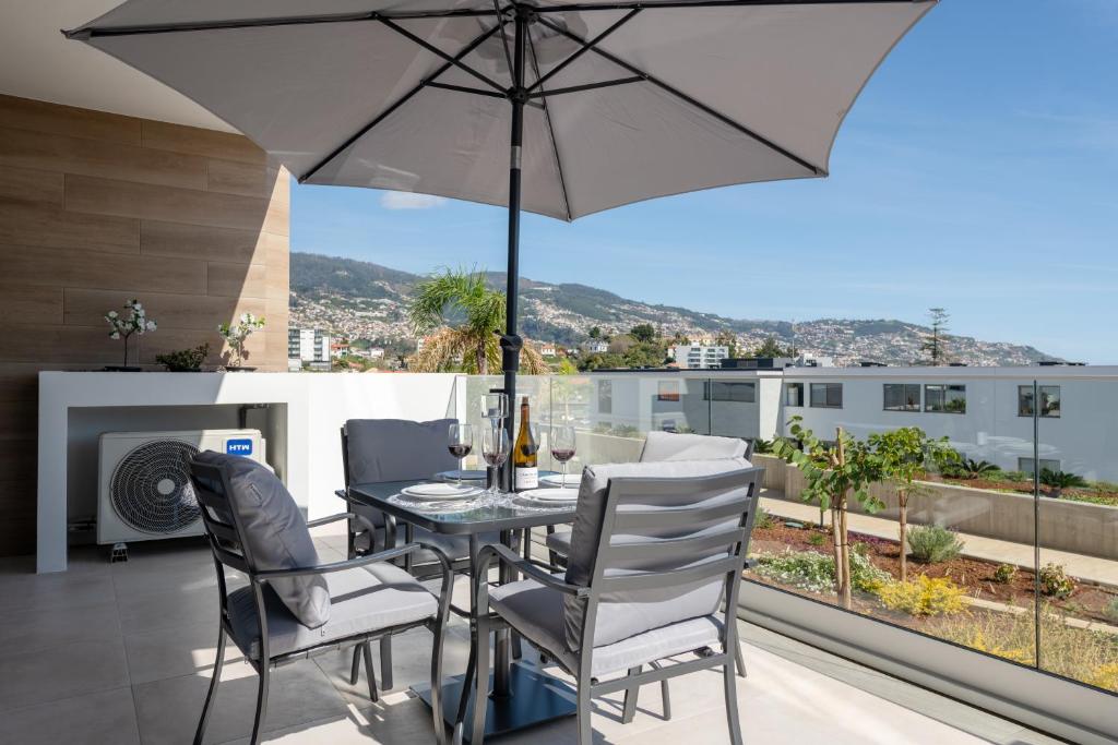 Un patio con una mesa y sillas y una sombrilla. en The Prince Apartment, en Funchal
