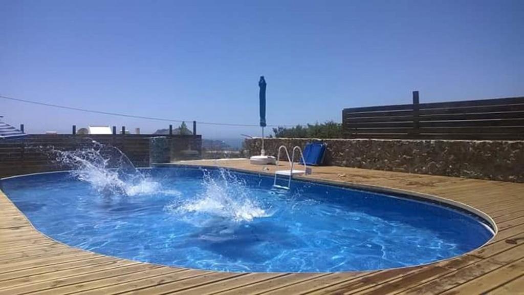 a swimming pool with water splashing in it at Villa Jazmin in Marioú