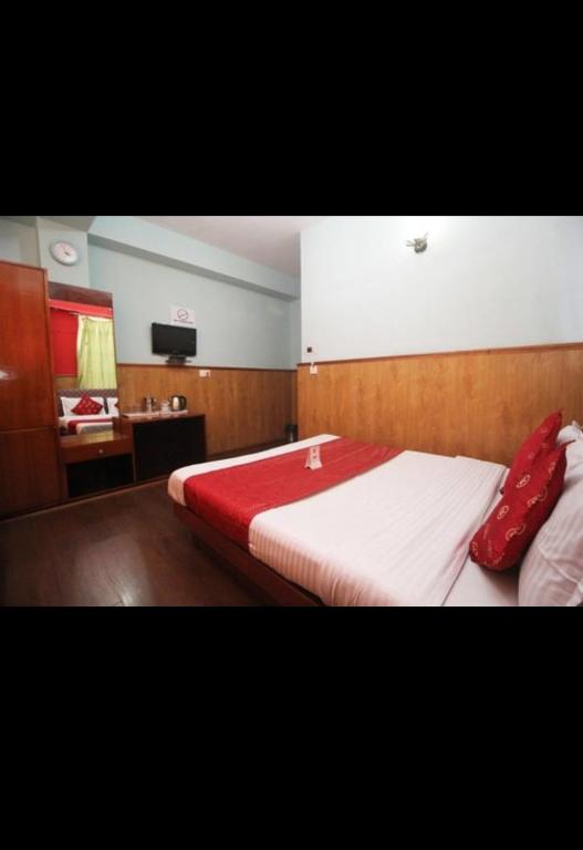 甘托克的住宿－Hotel Yatung，一间卧室配有一张大床和红色枕头