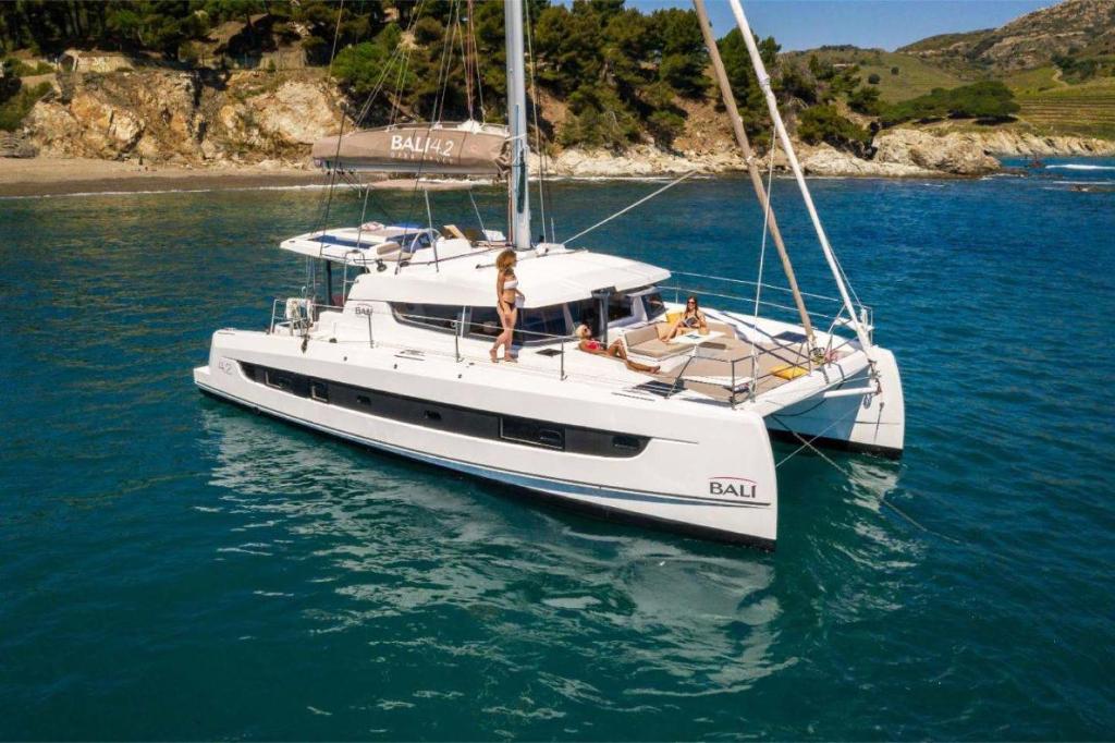 a white boat in the water with people on it at Catamarano 43 Foil e Kite Equipment in Marina di Portisco