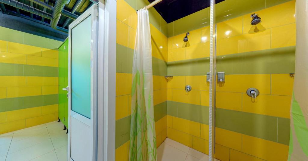 a bathroom with a shower with yellow and green stripes at Green Cube Capsule Hostel in Sofia